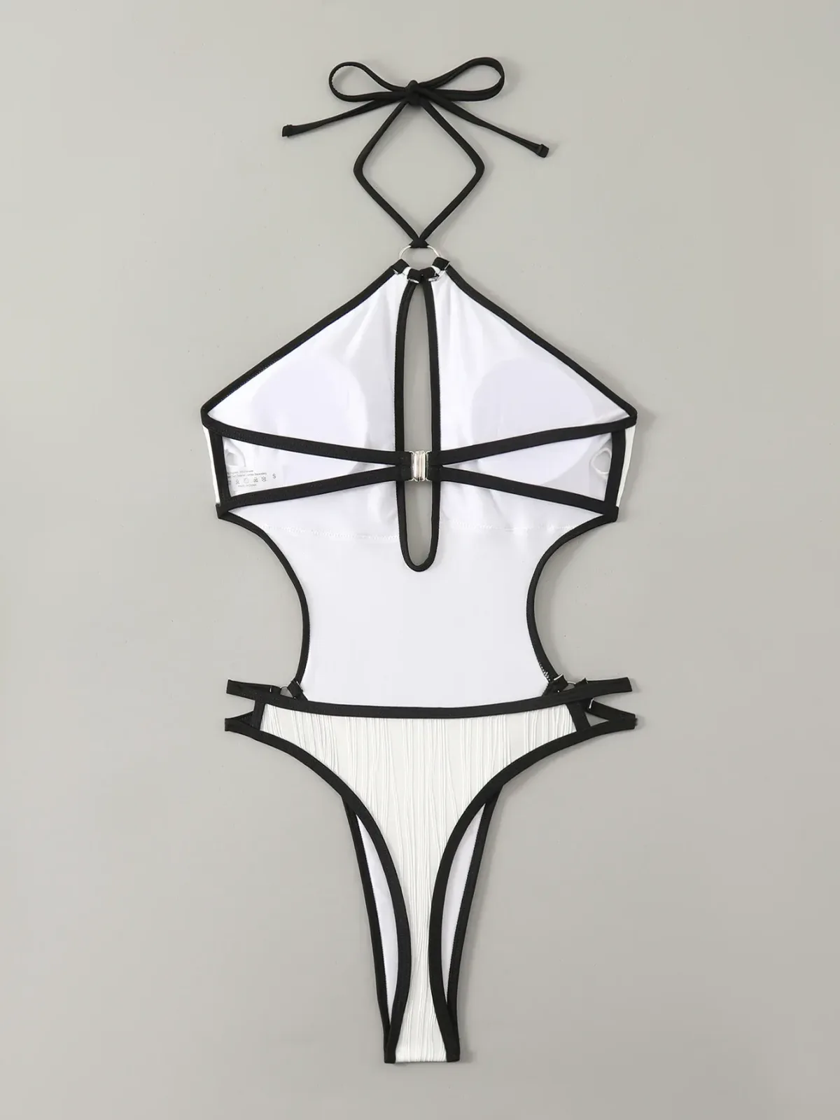 high cut leg of the white cutout swimsuit laid flat